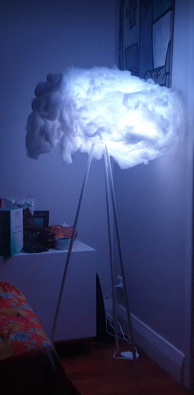 An art installation shaped like a glowing cloud on a tripod.