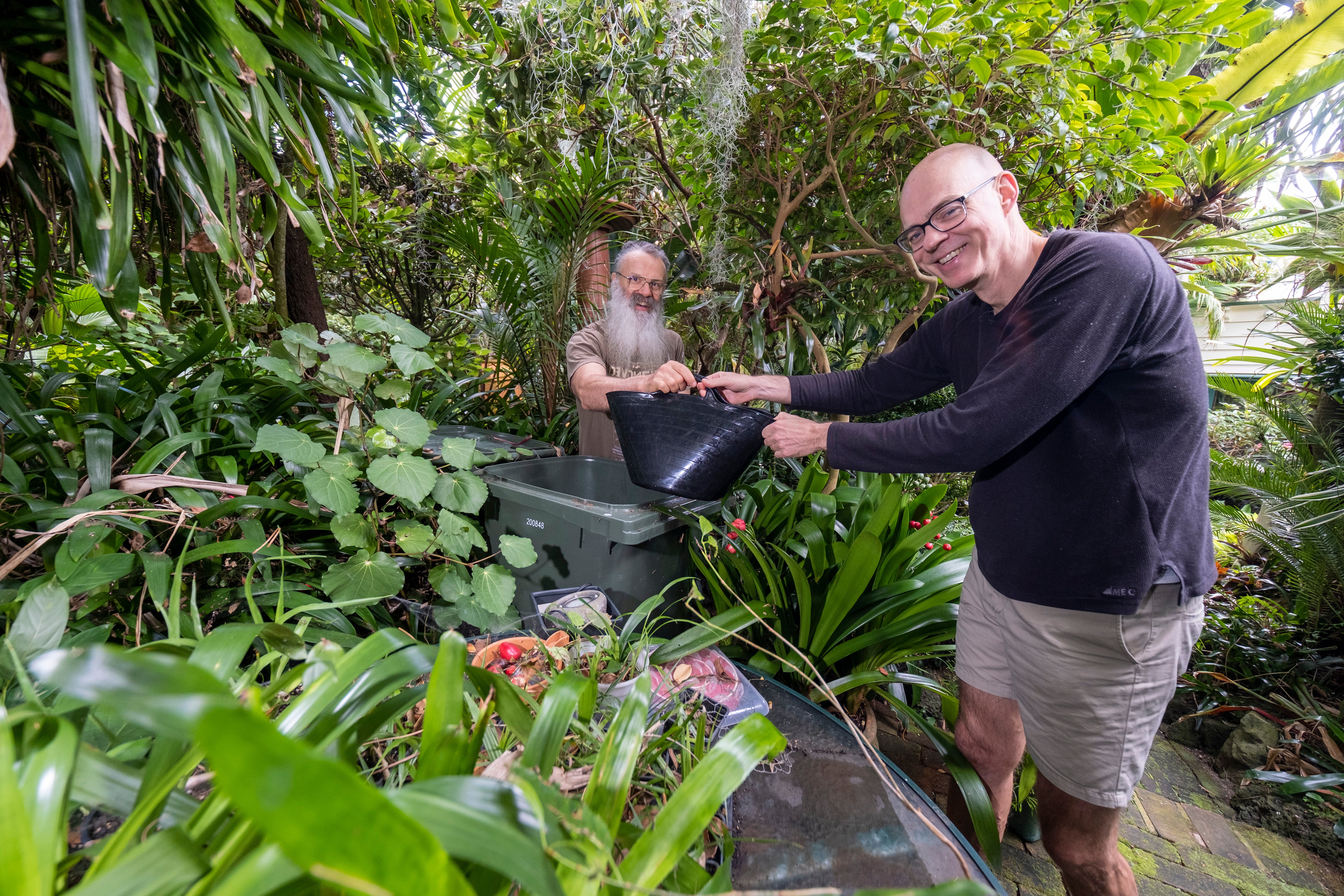 Mark and Gene water their garden with water stored in bins and barrels. 