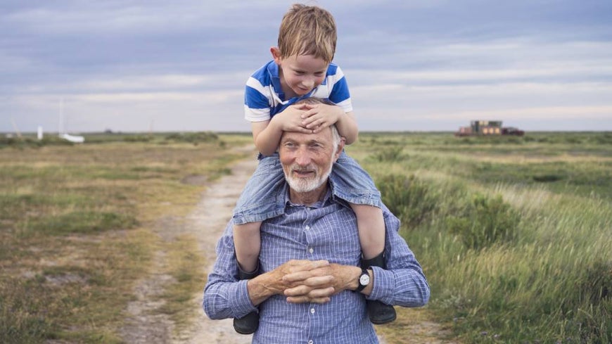 Grandparent carries grandson on his shoulders
