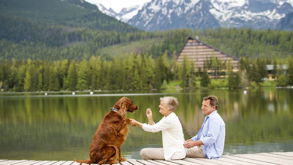 Seniors couple on holiday at the lake with their dog.