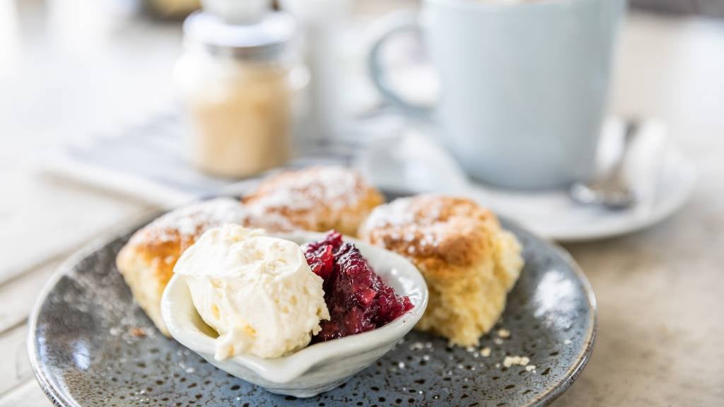 A plate of scones with jam and cream