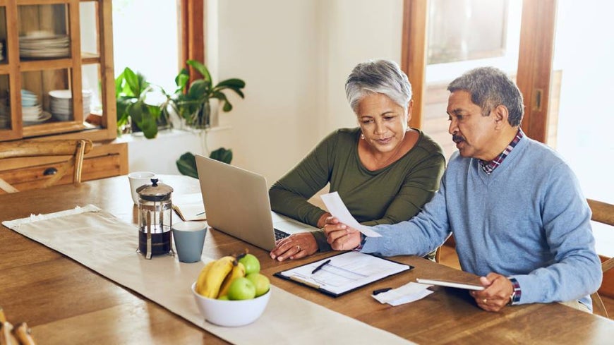 over 50s couple discussing matters at table