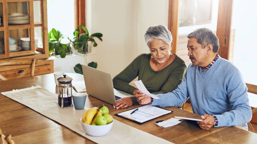 over 50s couple discussing matters at table 