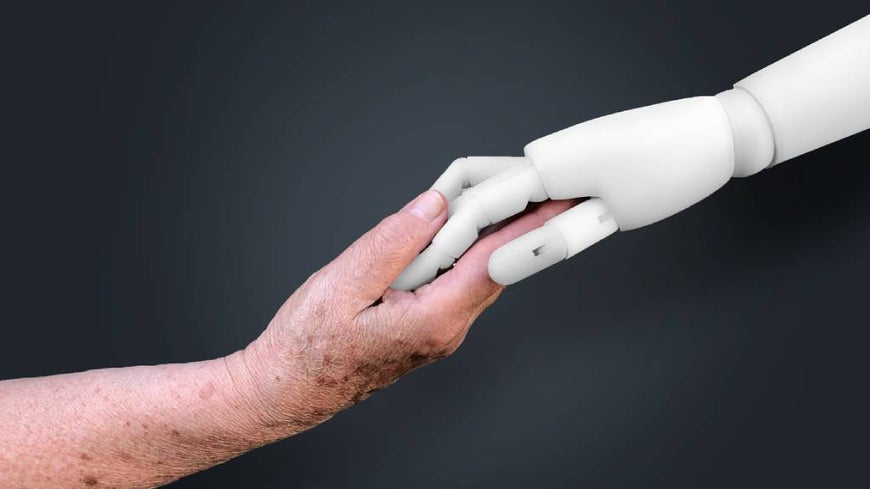Robotic arm holds hands with senior. 