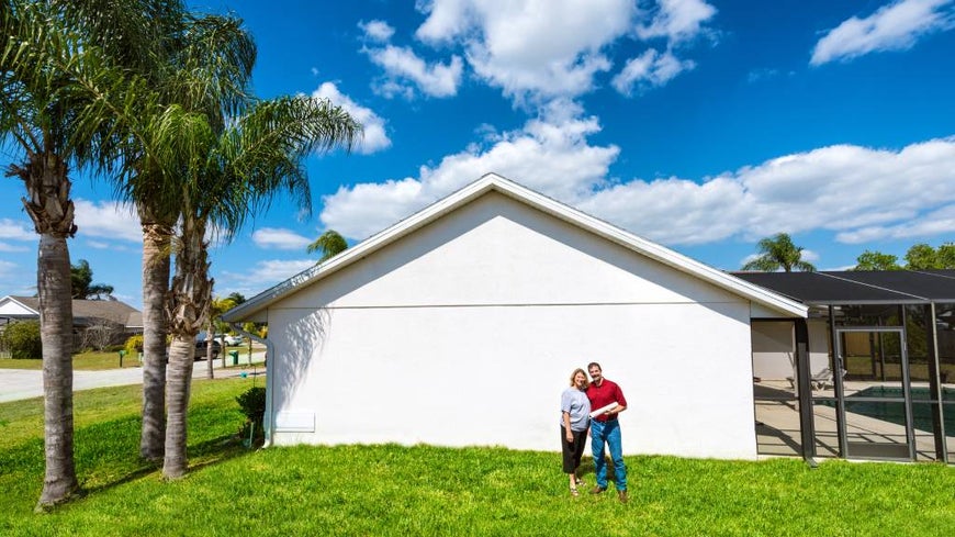 Mature couple in front of their new regional house