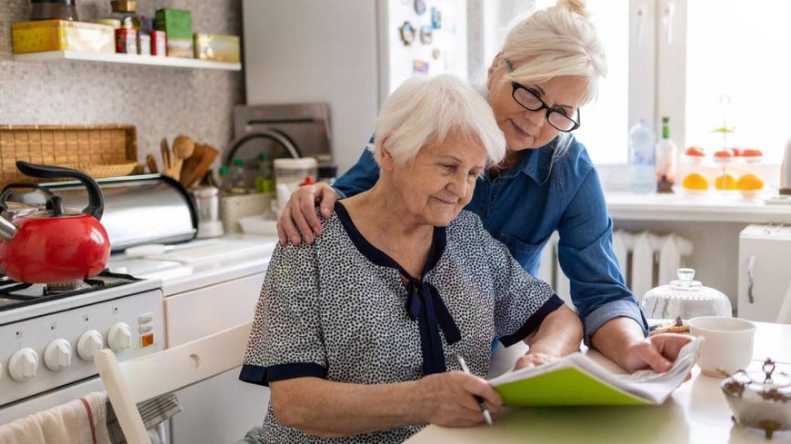 Woman is cared for by aged care worker in her home.