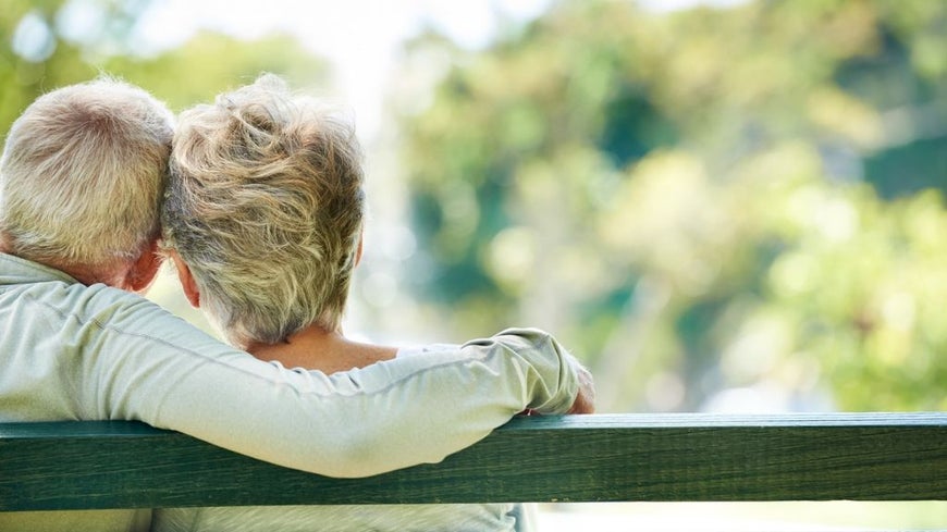 older couple sitting on bench discussing funeral