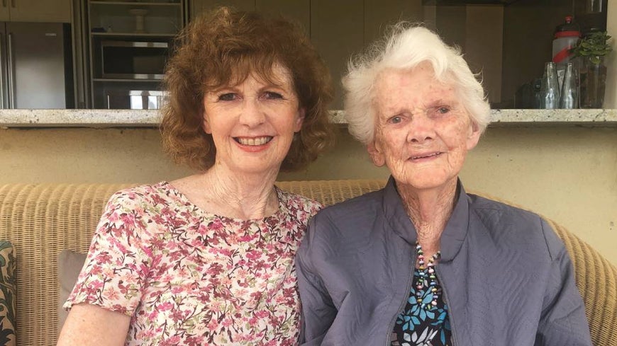 Romayne and her mother Elaine sit together on a sofa