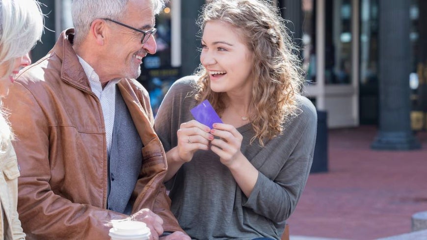 Young woman receives credit card from grandparents