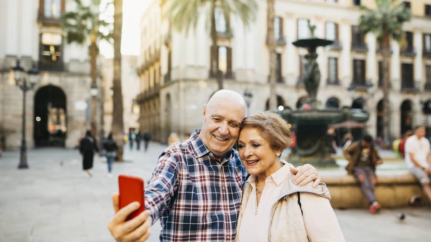 Senior couple take a selfie while on holiday.