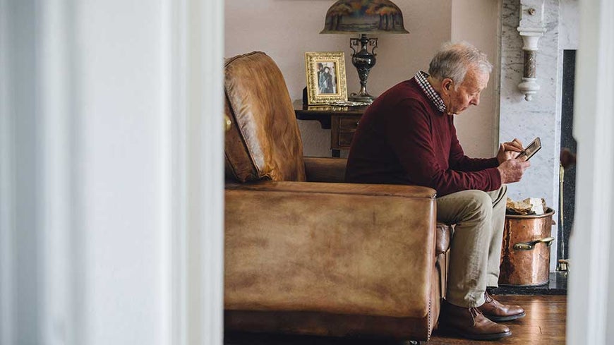 sad man staring at photo in home