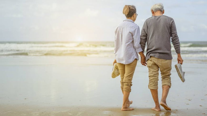 Senior couple watching sunset at the beach