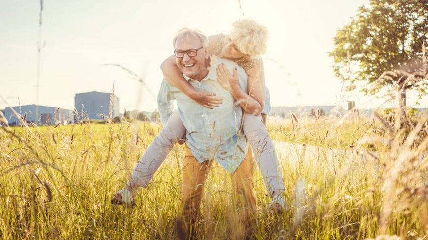 senior couple embracing in grasslands