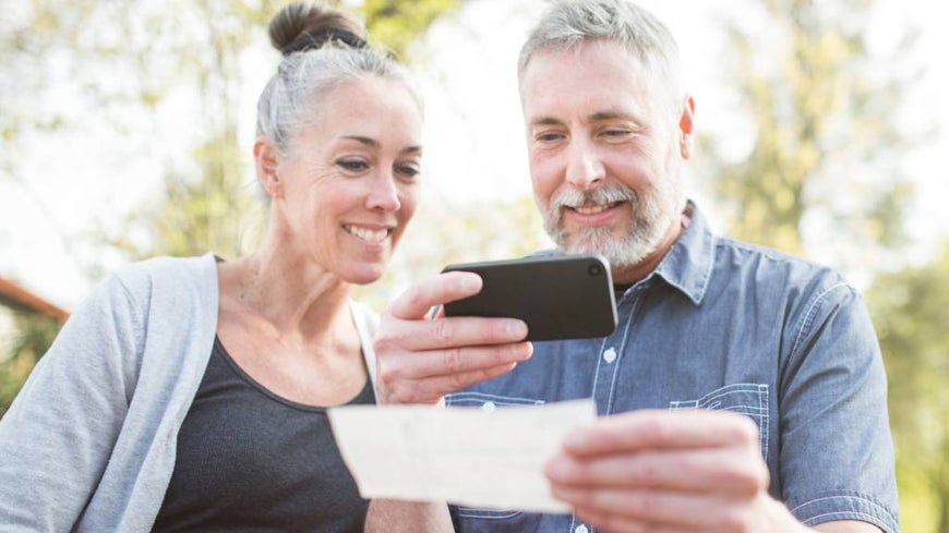 mature couple scanning document with  phone