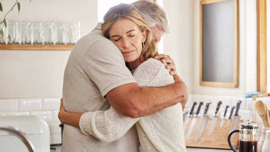 Senior couple embraces after loss of a loved one. 