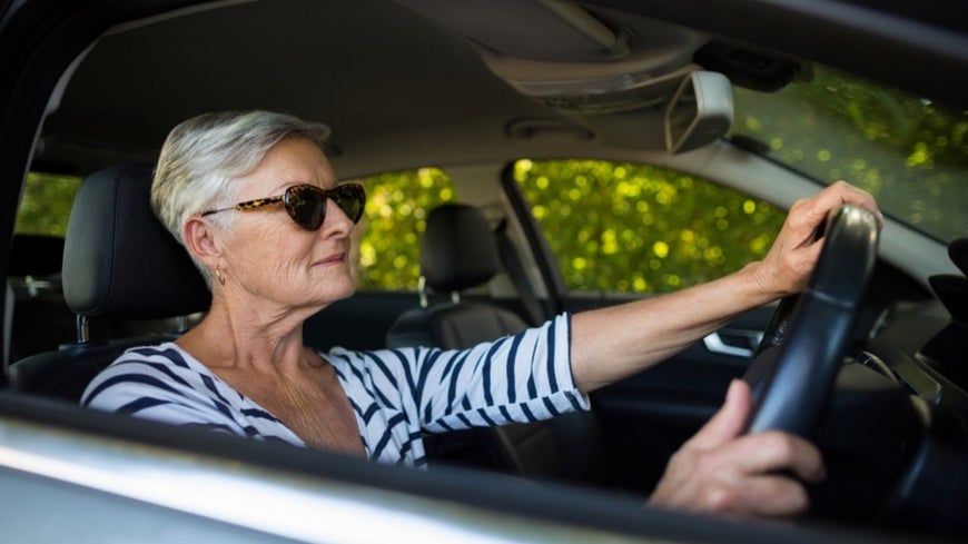 Senior woman driving new car