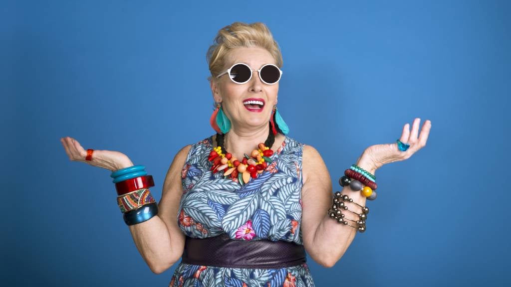 Mature woman in bright, summer dress with lots of colourful jewellery.