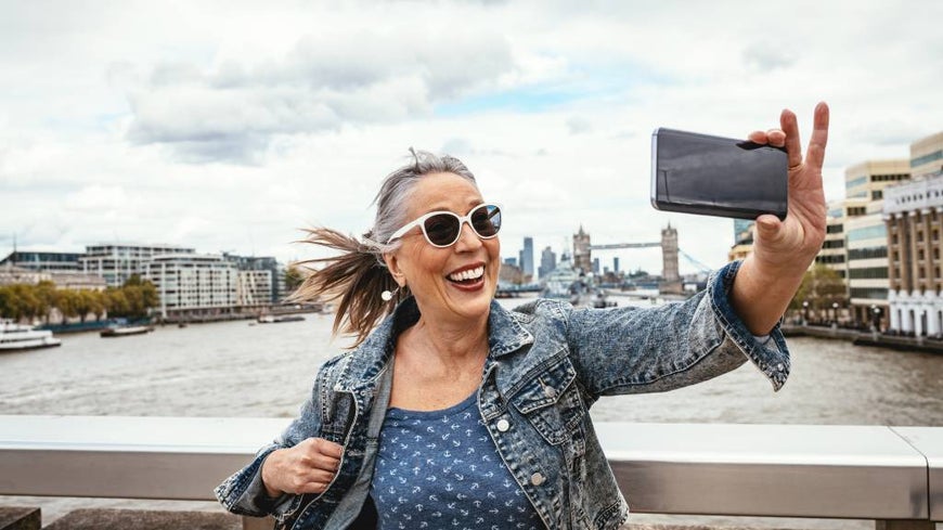 SENIOR WOMAN TAKES A SELFIE WHILE TRAVELLING