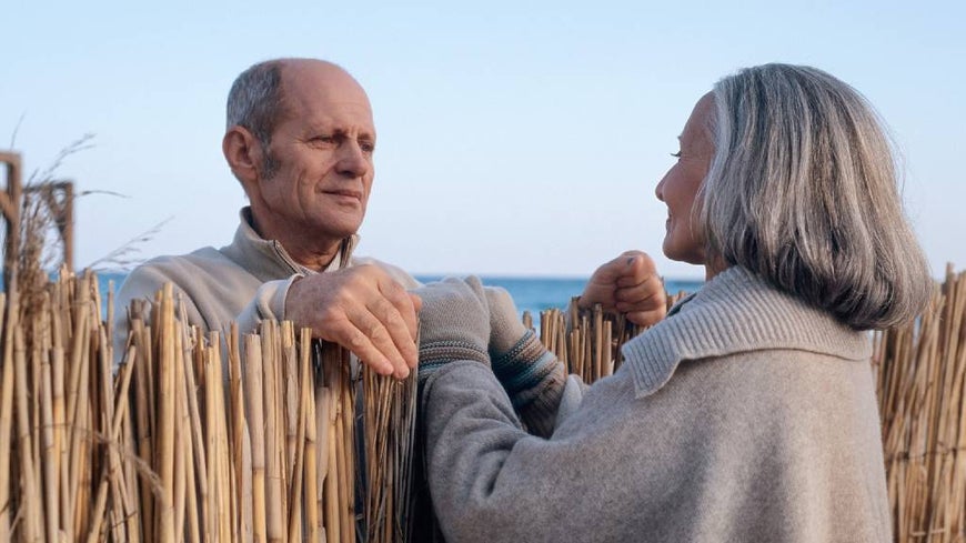 Senior couple lovingly looking at each other over fence