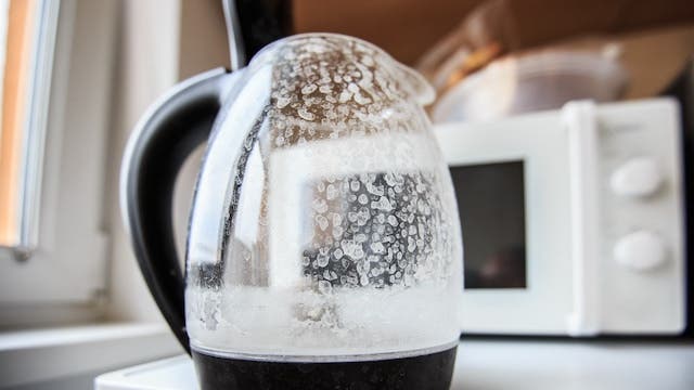 Glass kettle with white scaling marks visible in the jug