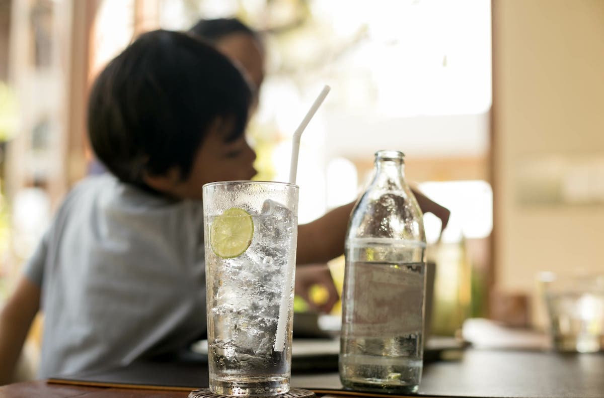 Boy drinking water with ice and lemon