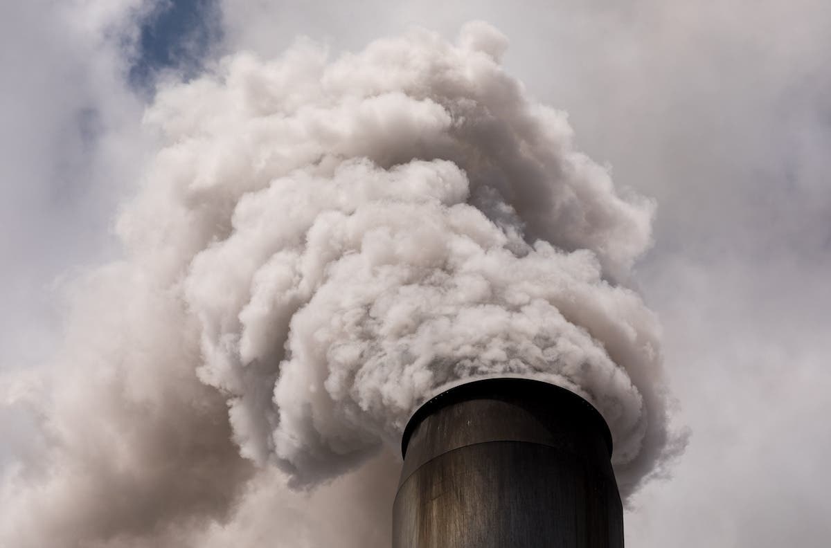 Thick smoke coming out of a industrial flue gas stack