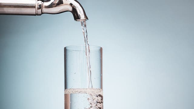 Water pouring into a glass from a tap