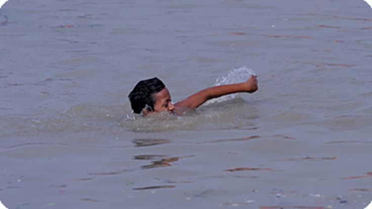 Boy swimming in a dam 
