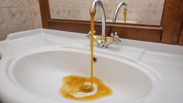 Brownish yellow water coming out of a bathroom sink tap