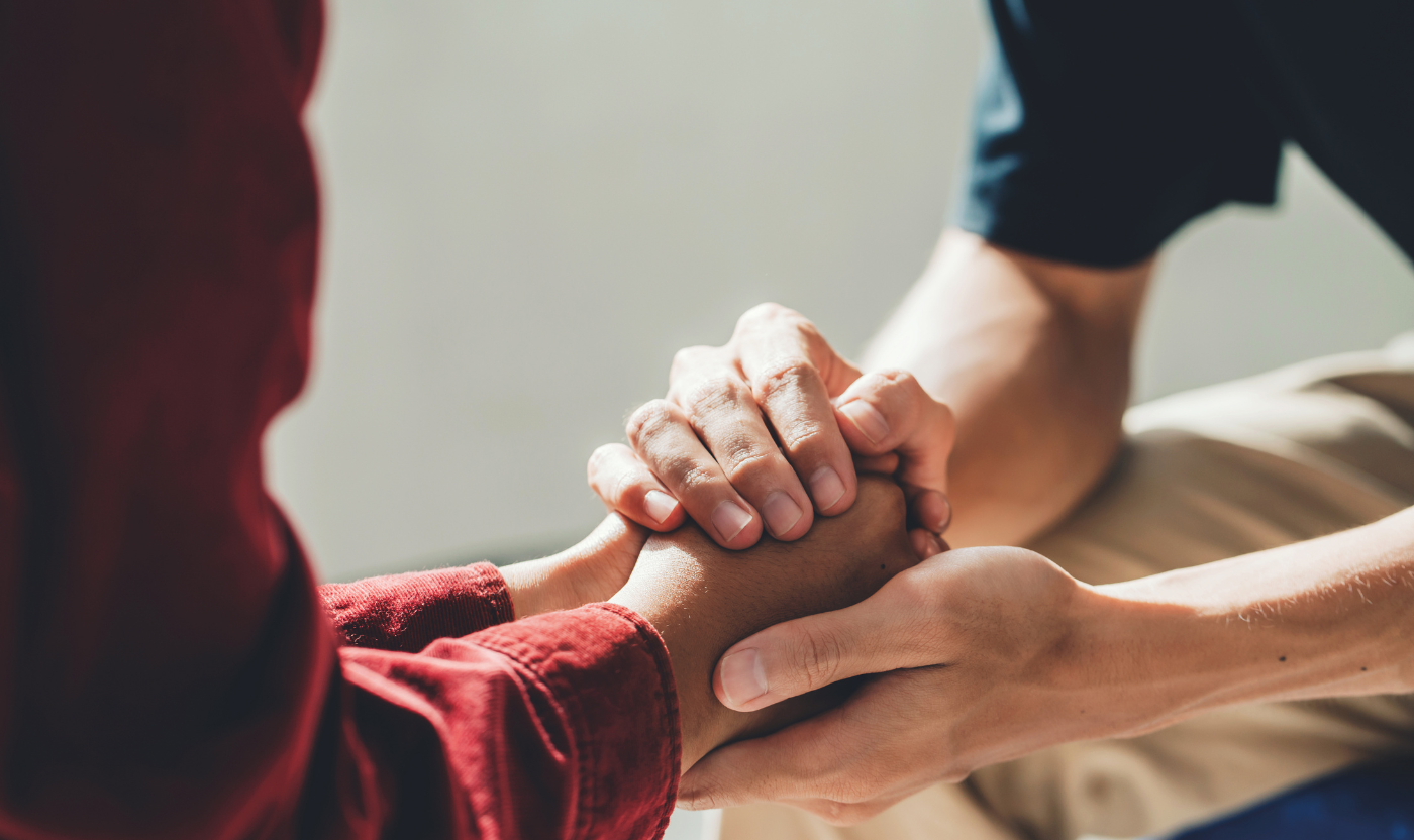 Two people gently hold hands, offering comfort and understanding. This image conveys empathy and emotional support following pregnancy loss.
