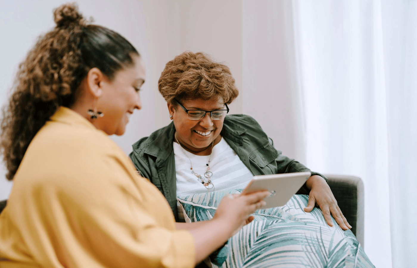 Mid shot of a woman talking to her therapist about menopause. They are both smiling.