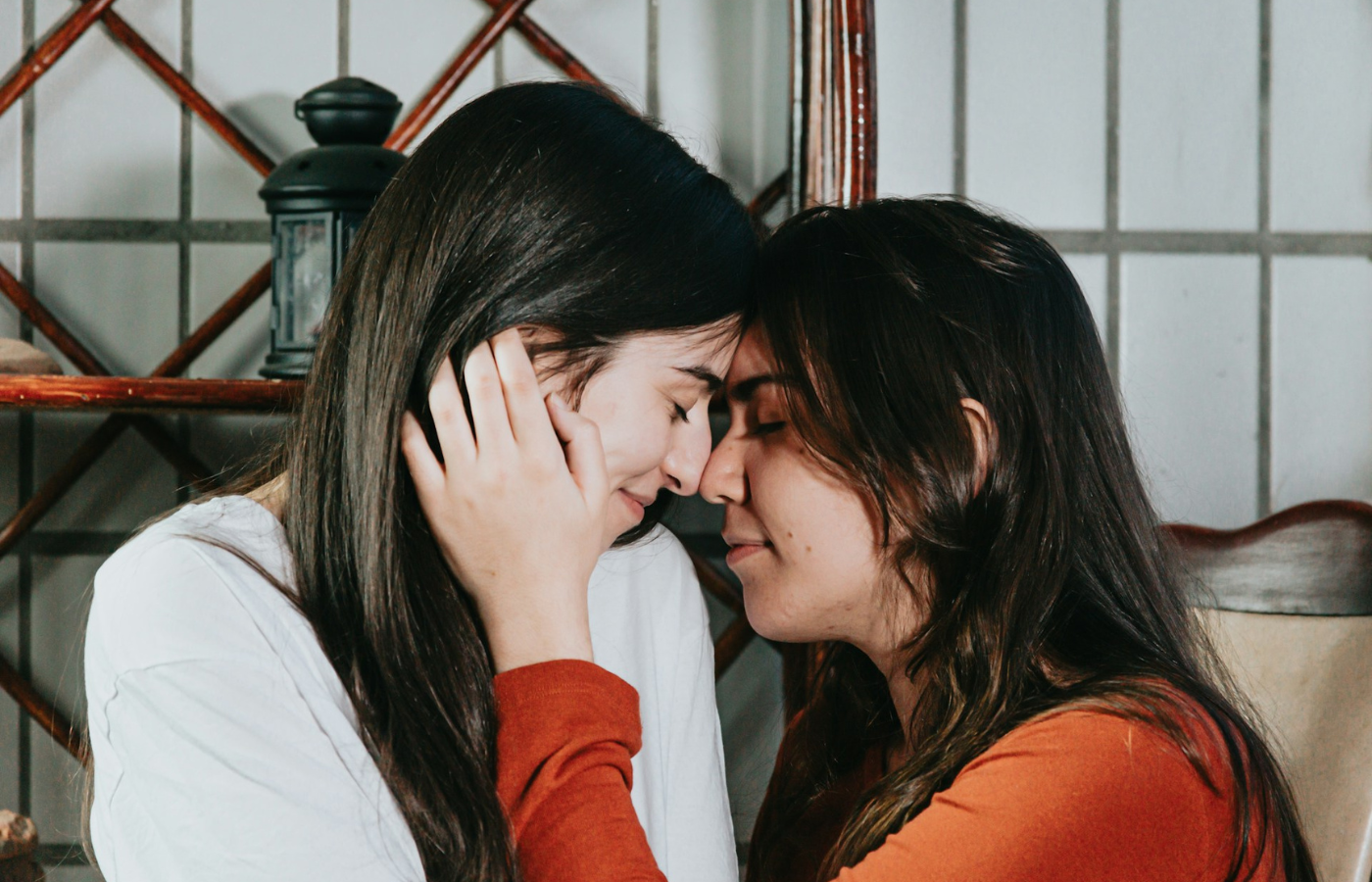 A close up of a couple - they are both smiling with their eyes closed. They are face to face and their noses touch. They are feeling connected after a couples therapy session.