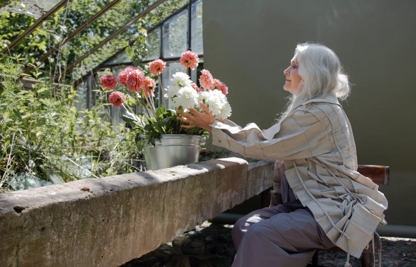 Mid shot of a woman tending to freshly cut flowers. She is reflecting on the metamorphosis that is menopause.