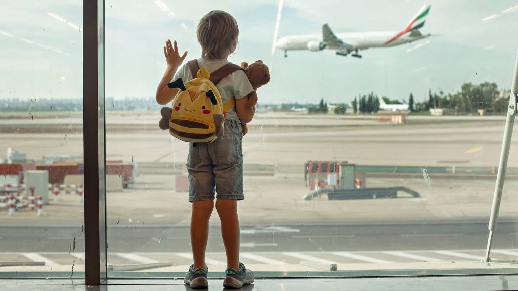 Child watches plane land at airport