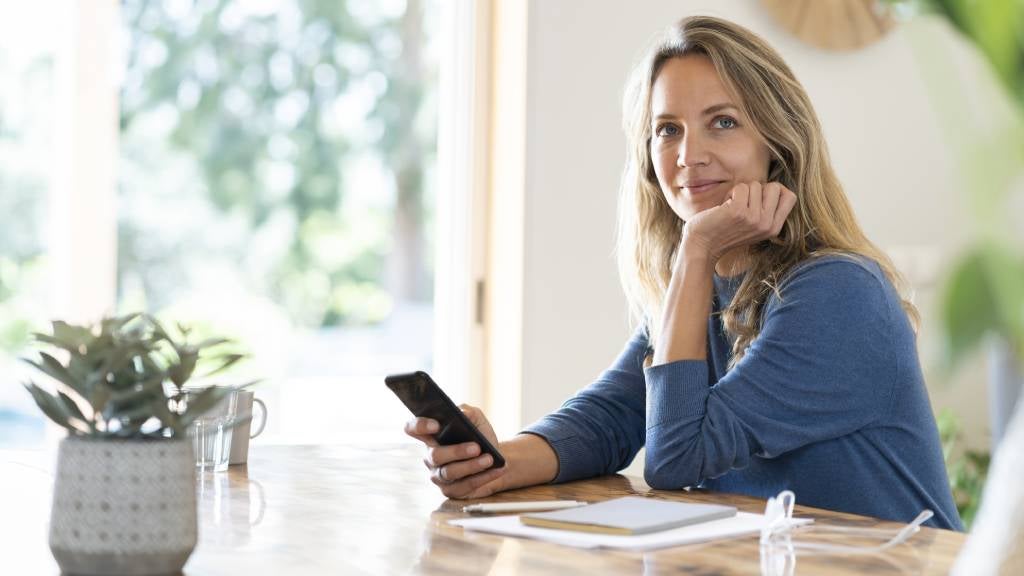 Woman using smart phone sitting at table