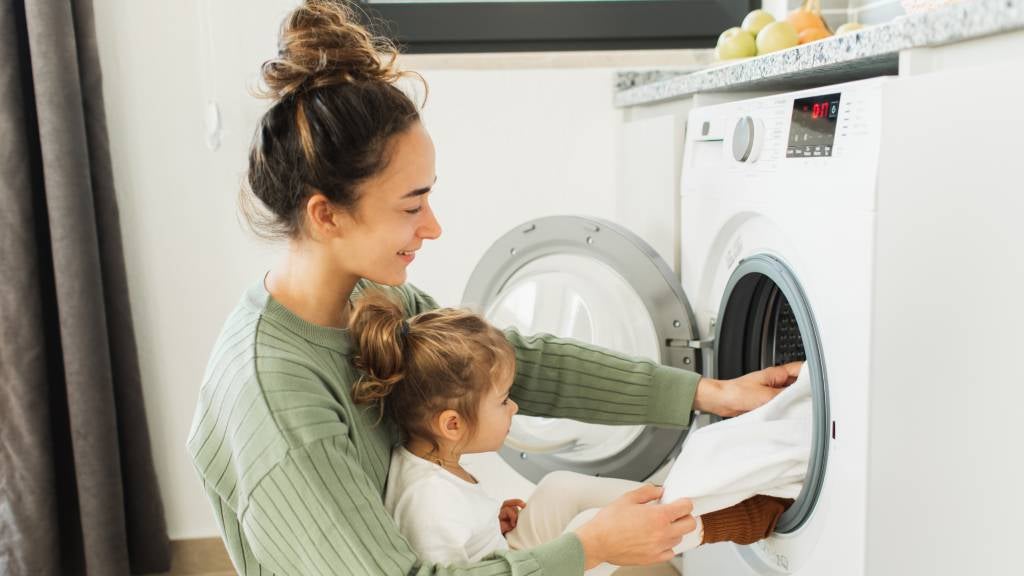 Mother and child pulling clothes out of the washing machine