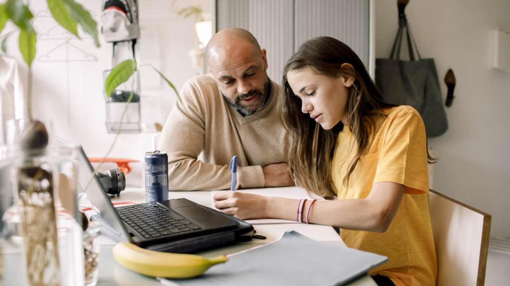 Father home schooling his daughter.