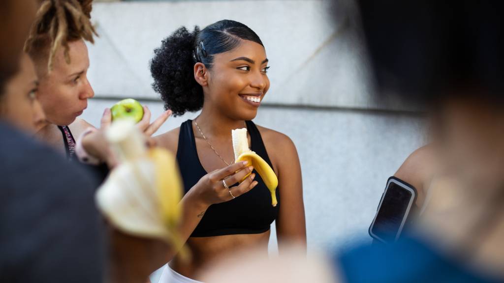 group of friends eating fruit after workout