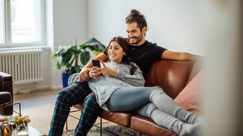 Happy couple chilling on the couch together.