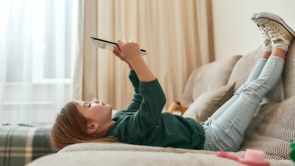 Young girl playing games on tablet