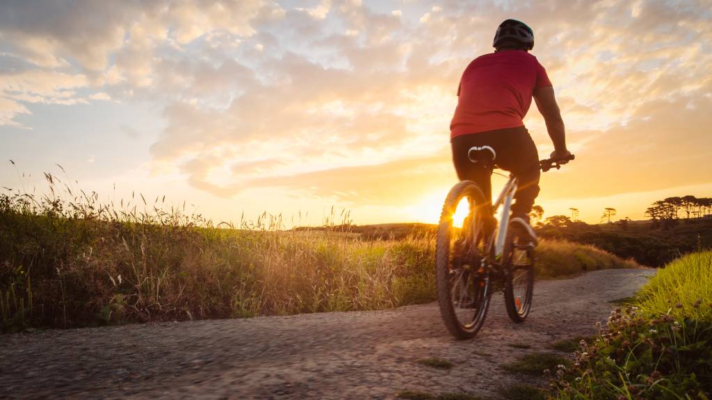 man riding bike in sunset