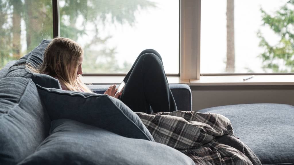 Teen sitting on lounge using mobile phone