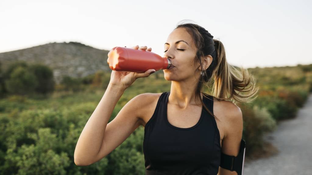 Girl drinking from water bottle exercising