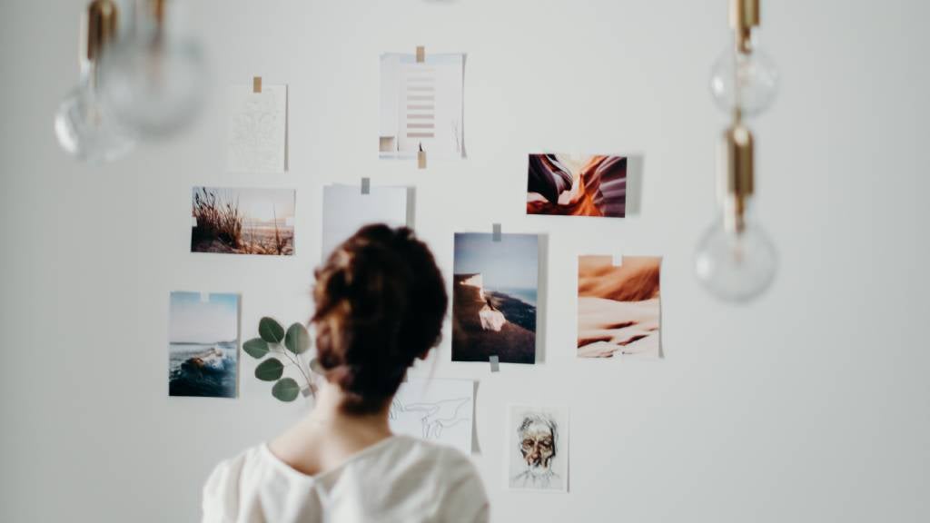 Woman stands in front of photographic vision board