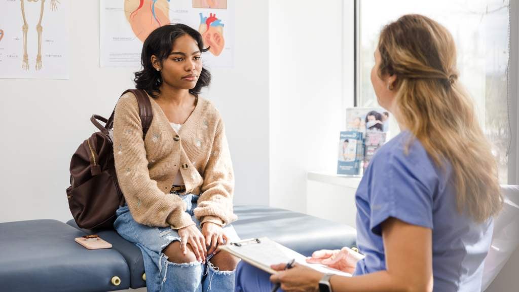 Young woman sitting on a treatment bed in doctor's office