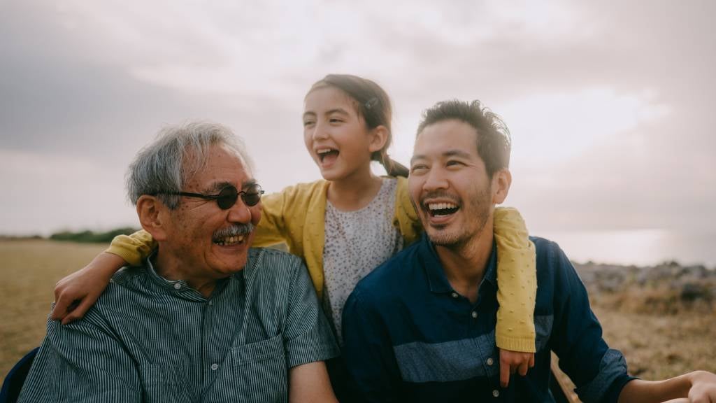 Young girl laughing with her father and grandfather