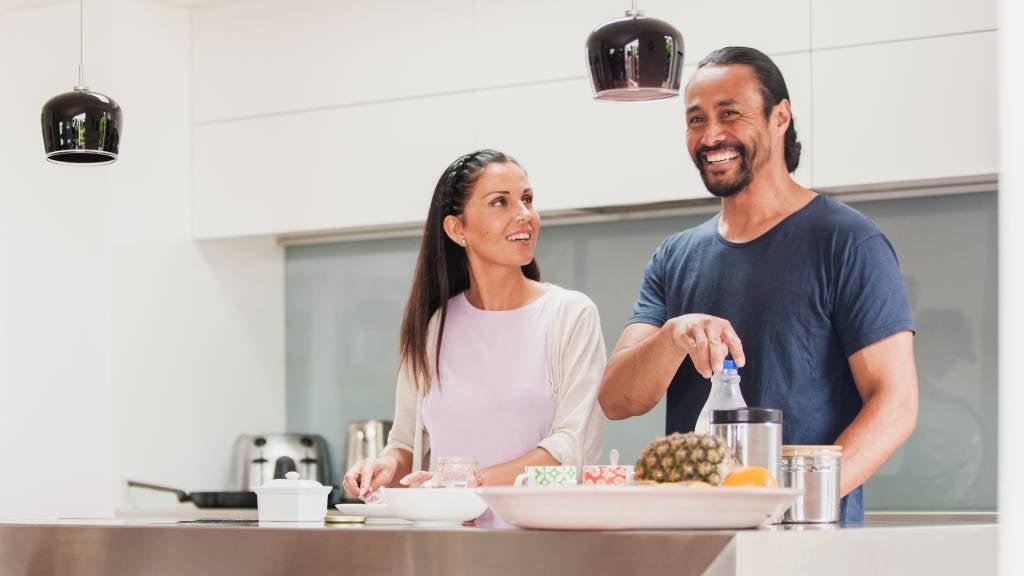 A young couple prepare a meal in their kitchen