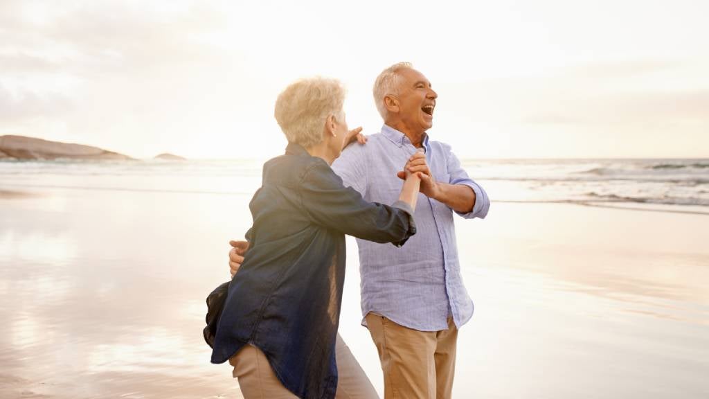 Senior couple happy and dancing on the beach.