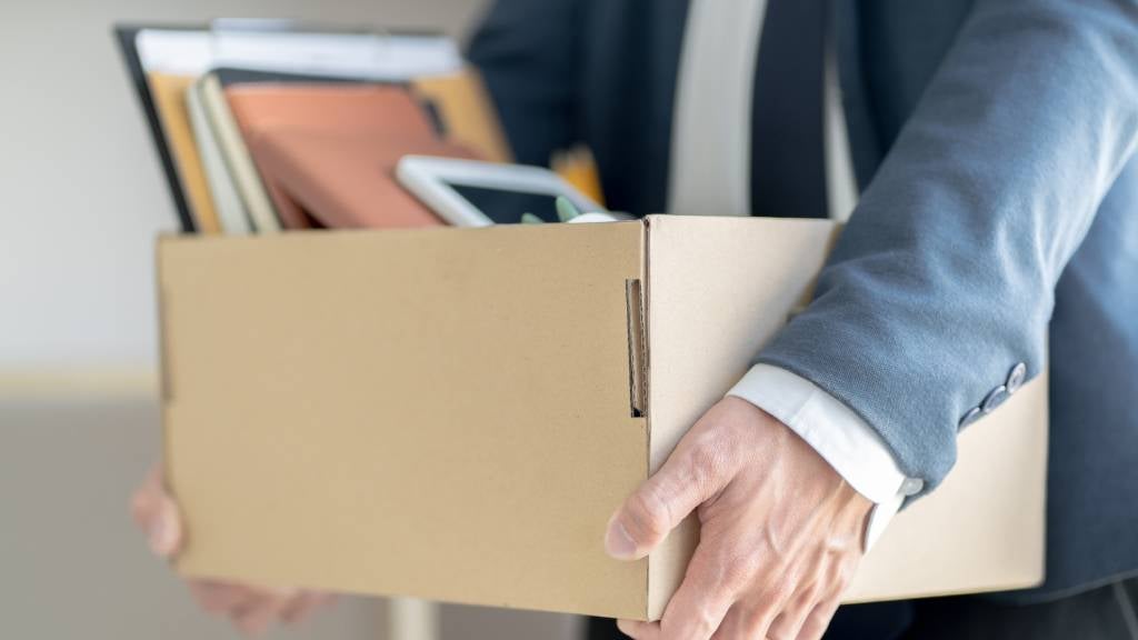 Male employee carrying a box of his belongings