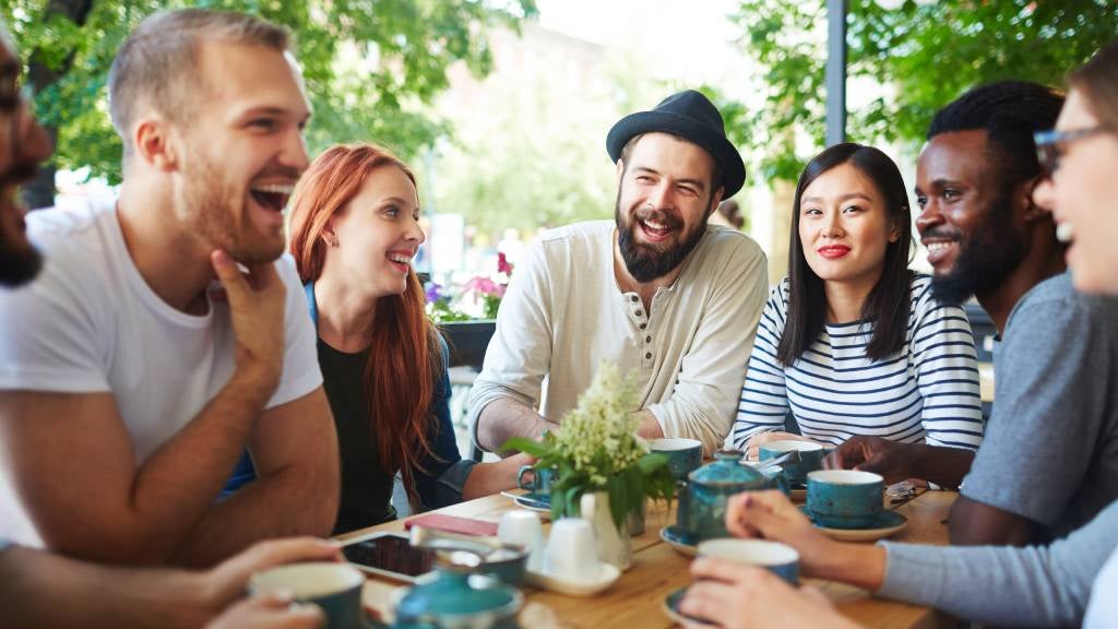 Group of friends laughing over coffee